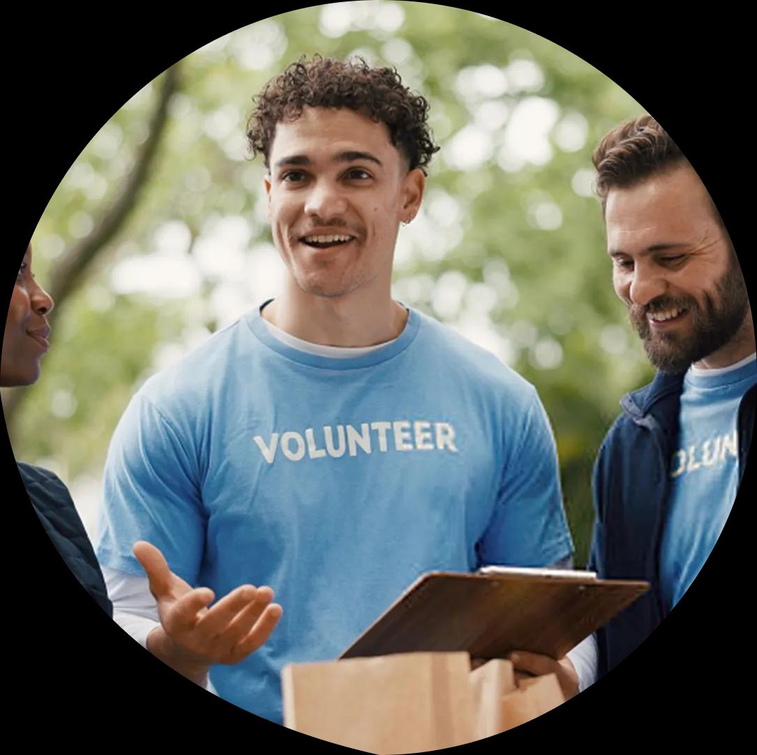 Volunteers talking while holding a clipboard and a delivery box